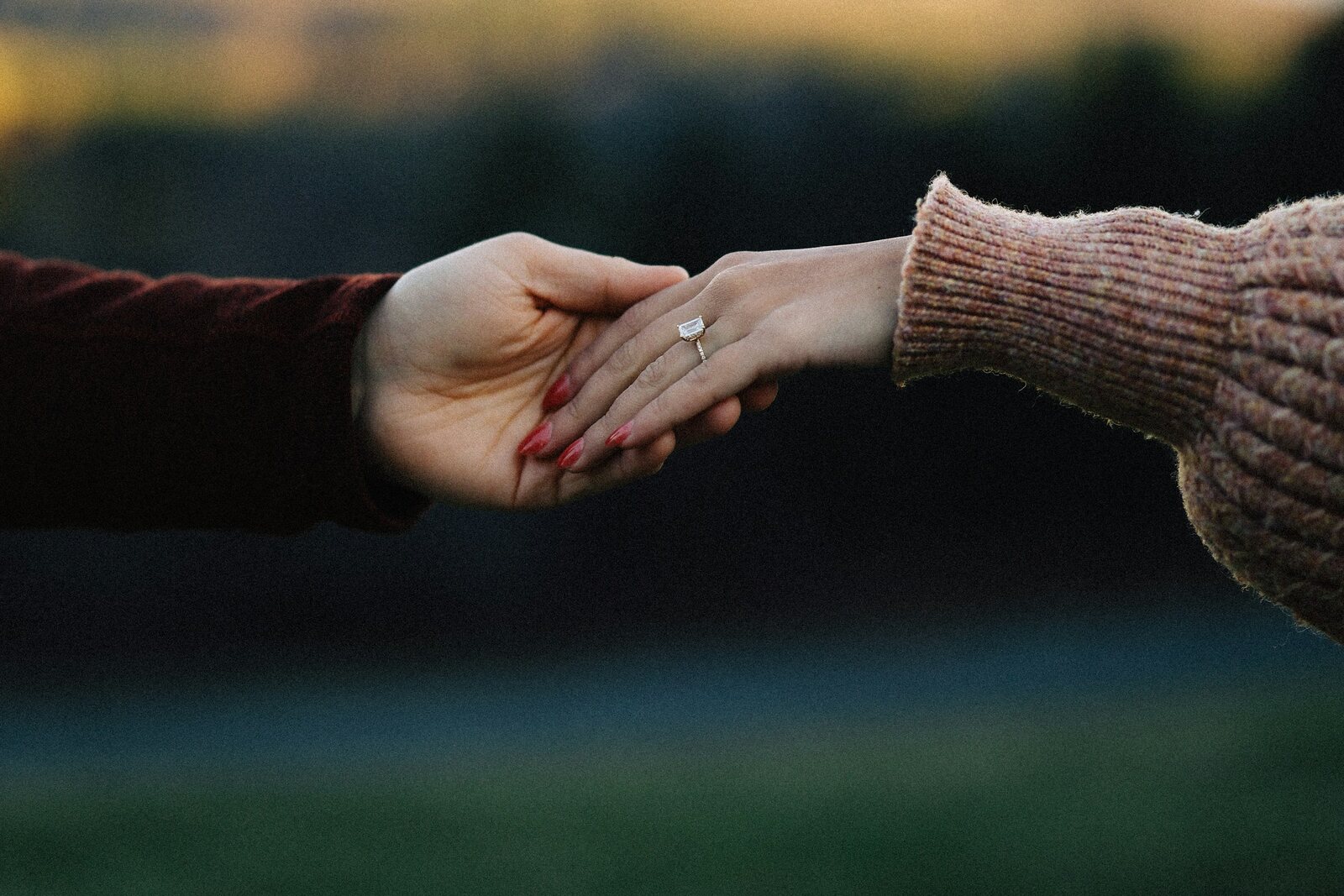 Couple holding hands showing an engagement ring